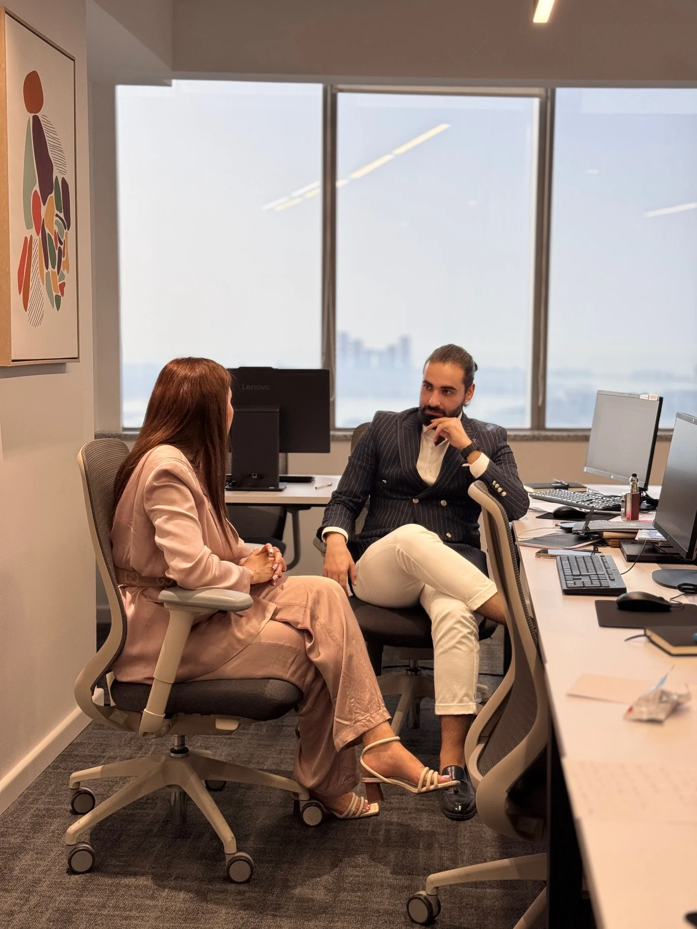 Two professionals having a one-to-one career conversation in a modern office